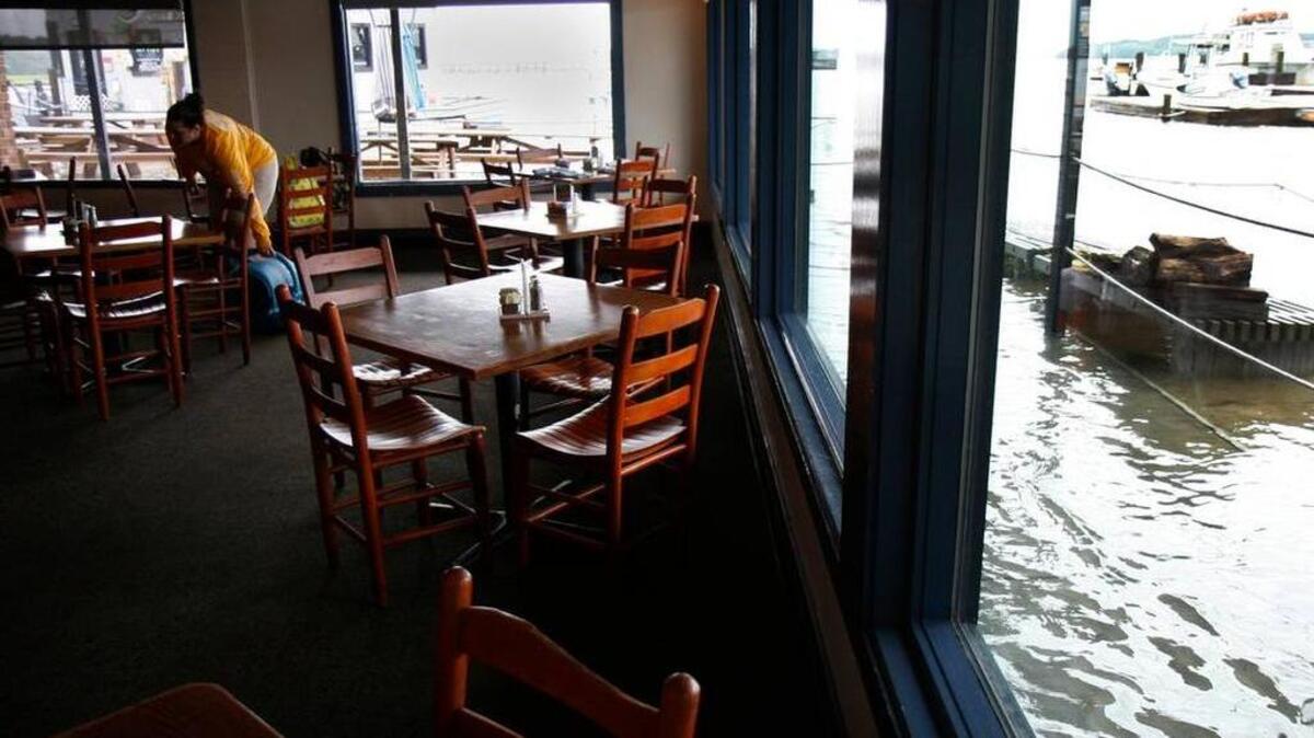 Odyssey Merritt positions a fan at Hudson's Seafood House on the Docks on Hilton Head Island on Oct. 28 to help dry the carpet in the main dining room.