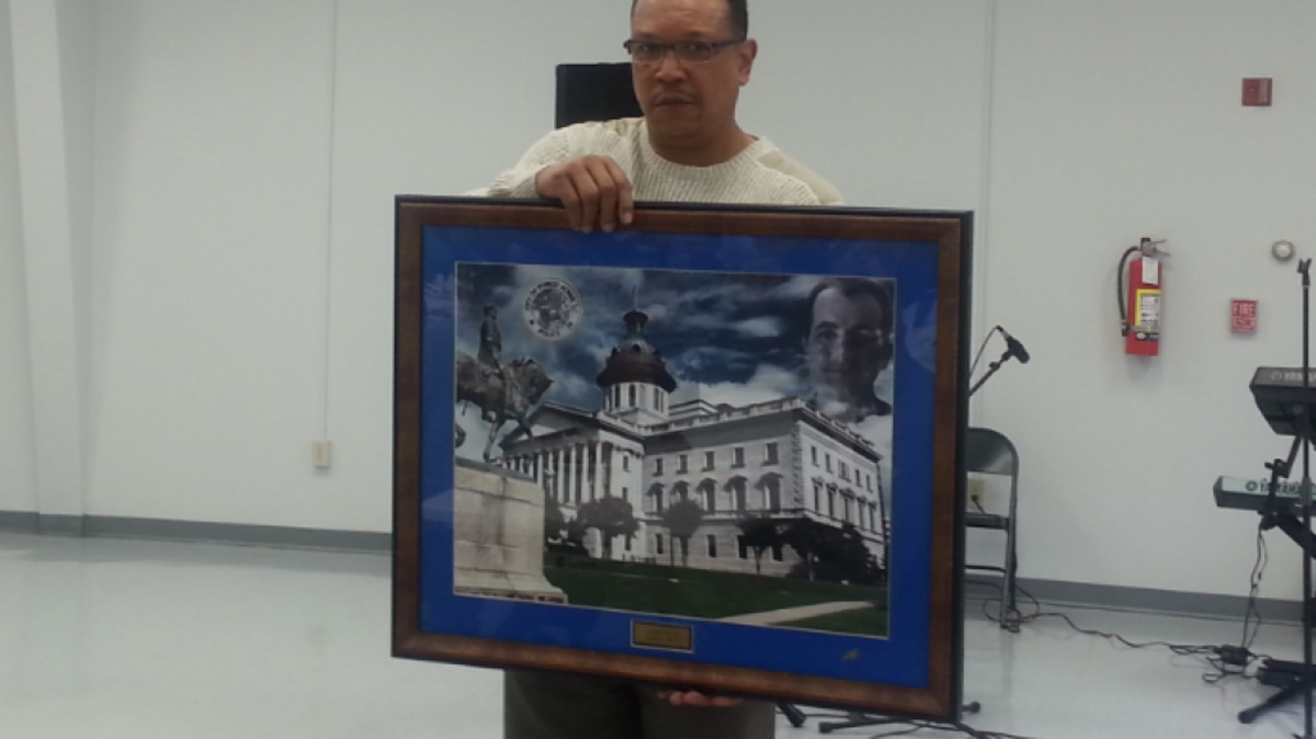 Karl Wilkes presents a painting of fallen Forest Acres officer Greg Alia