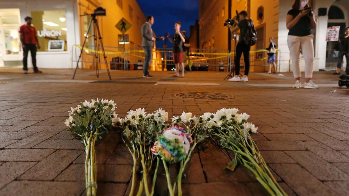 Flowers and other mementos are left at a makeshift memorial for the victims after a car plowed into a crowd of people peacefully protesting a white nationalist rally Saturday in Charlottesville, Va.
