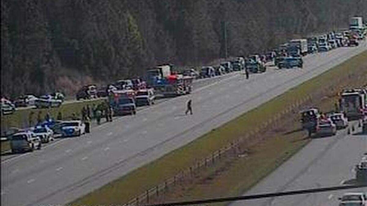 In this image made from a NCDOT traffic camera, emergency officials divert traffic on I-540 near Leesville Road after a small plane landed near the interstate on Tuesday morning, March 29, 2016.