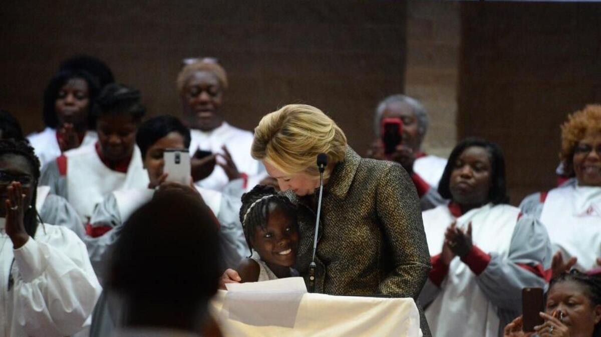 Democratic presidential candidate Hillary Clinton hugs Zianna Oliphant after inviting her to the stage as she finishes speaking at Little Rock AME Zion church in uptown Sunday morning, a week after protests following the police shooting of Keith Lamont Scott. Oliphant gave a tearful speech to Charlotte City Council recently.