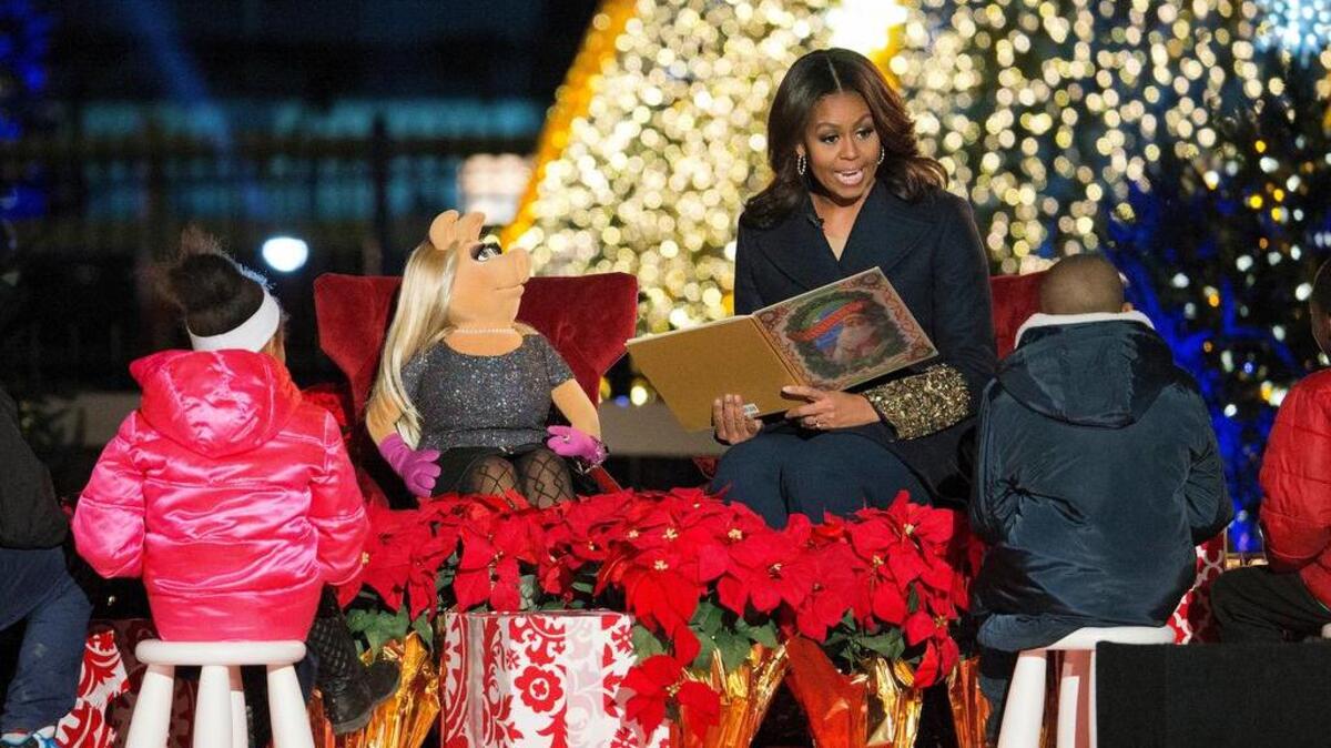 FILE - In this Dec. 3, 2015, file photo, first lady Michelle Obama with Miss Piggy, left, read 'Twas the Night Before Christmas for children on stage during the National Christmas Tree Lighting ceremony at the Ellipse in Washington. When Michelle Obama considered the daunting prospect of becoming first lady, she purposely avoided turning to books by her predecessors for guidance. Instead, she turned inward.