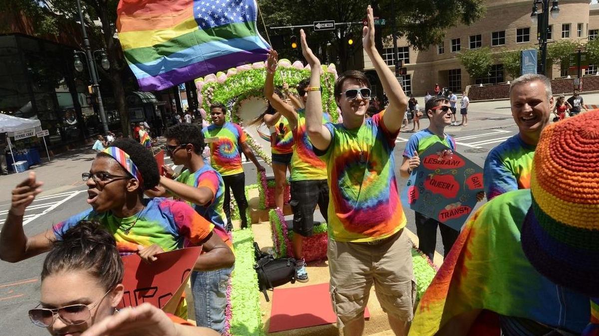 Time Out Youth members of Charlotte wave to the crowd from float during the 2013 Bank of America Charlotte Pride Parade.