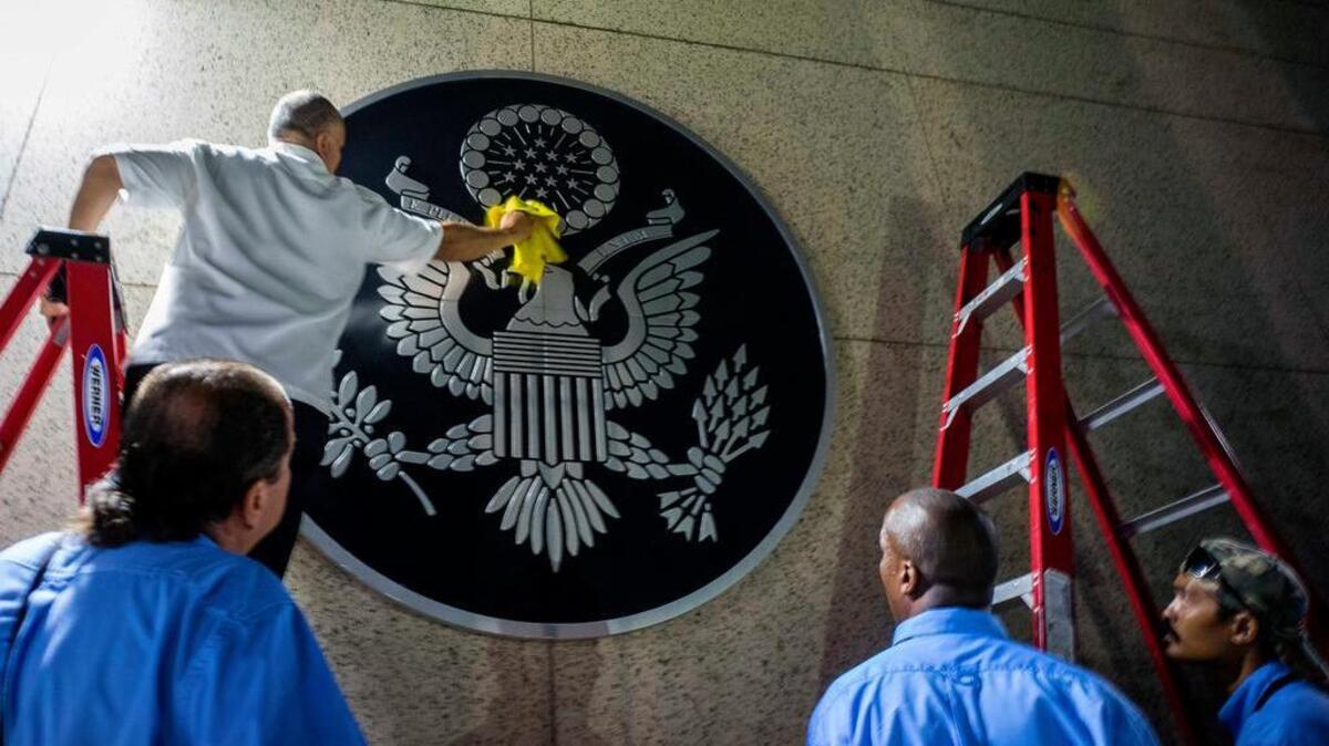 FILE - In this Aug. 14, 2015 file photo, a worker cleans the Great Seal of the United States at the newly opened U.S. embassy in Havana, Cuba. Secretary of State John Kerry arrived for the historic ceremony to raise the U.S. flag over the restored embassy.