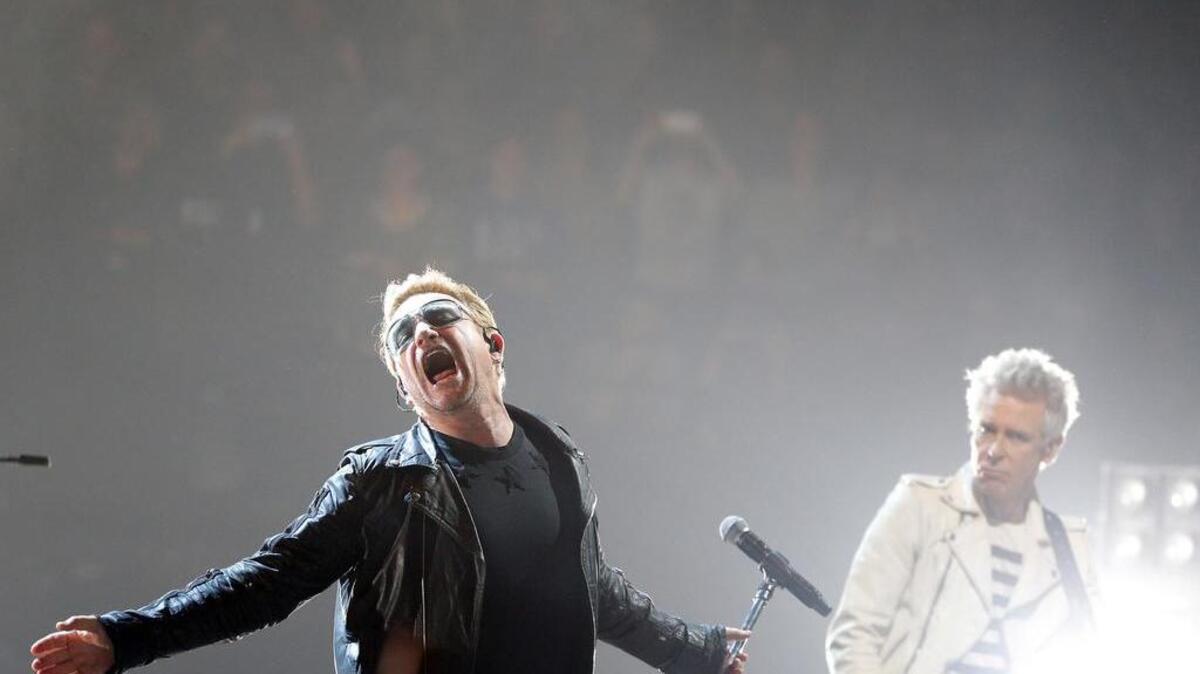 Bono, left, and Adam Clayton of U2 perform on stage during a concert, in Paris, Sunday, Dec. 6, 2015. U2’s performance in Paris on Sunday night wasn’t just about music, it had a mournful tinge, too. Frontman Bono paid respects to 130 people killed by extremists in Paris on Nov. 13, and 14 people killed in a mass shooting last week in California.