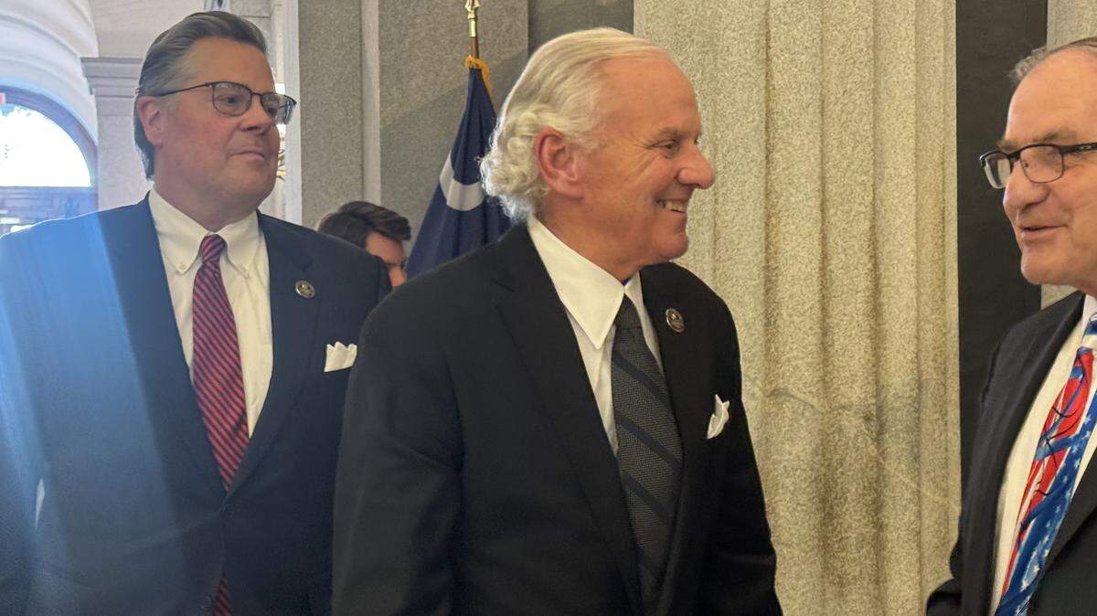 Gov. Henry McMaster greets South Carolina Department of Motor Vehicles Executive Director Kevin Shwedo as the governor’s Chief of Staff Trey Walker follows behind at the State House on Tuesday, March 3, 2026.