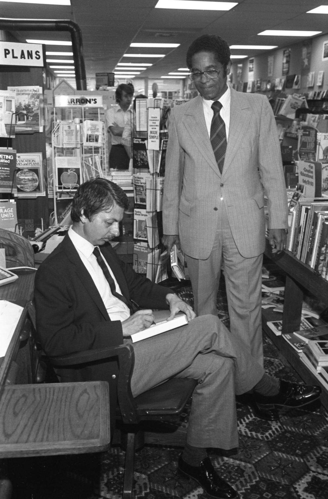 Journalist and author Jack Bass signs a copy of his book, Unlikely Heroes, for U.S. Judge Matthew Perry at the Happy Bookseller in the Richland Mall in 1980.