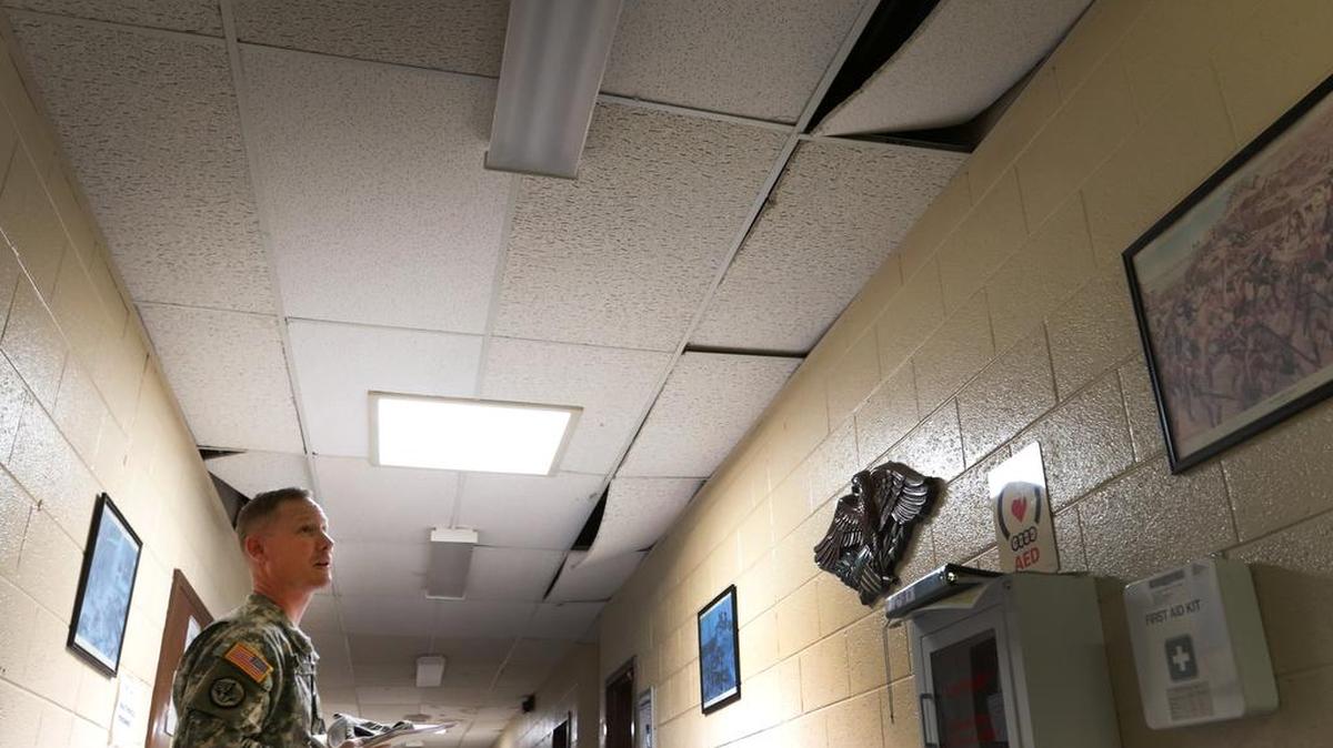 Maj. Marty Hanks observes damaged ceiling tiles that are falling out of the National Guard Armory in Greenwood on April 7, 2015.