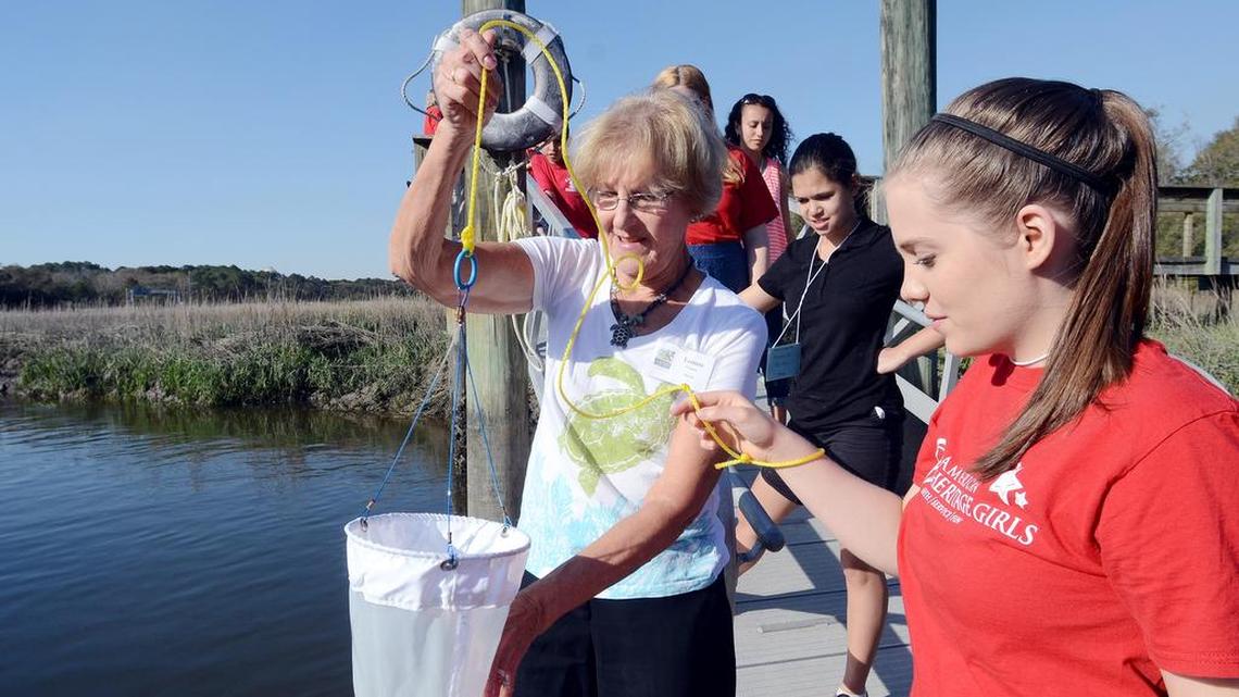 Coastal Discovery Museum volunteer Lenore Gleason helps Julia Herrin, 14, collect a water sample while leading a group of youngsters in a class on phytoplankton on Monday.