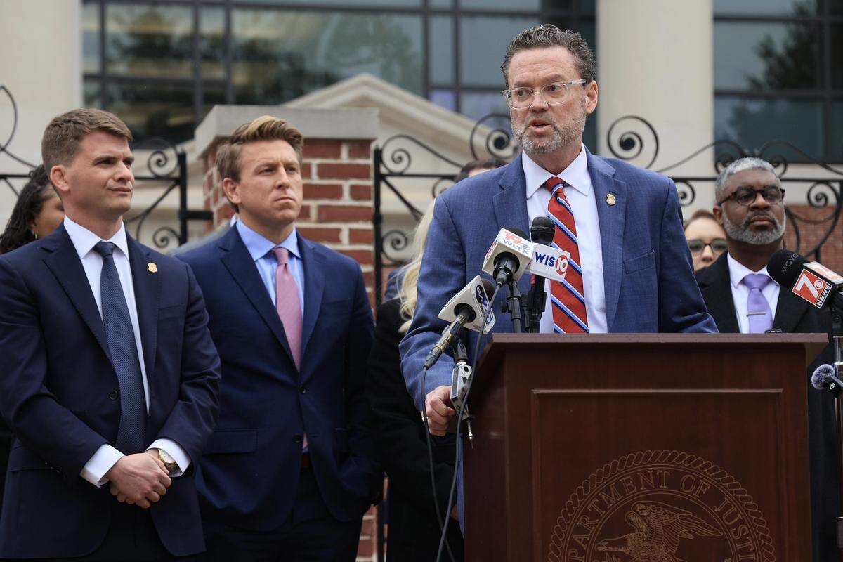Scott Mathews, assistant US attorney (from left) and Elliott Daniels, assistant US attorney, watch Lance Crick, 1st assistant US Attorney’s office, speak at a press conference following the sentencing of former state Rep. RJ May at the federal courthouse in Columbia, S.C., on Jan. 14, 2026. 