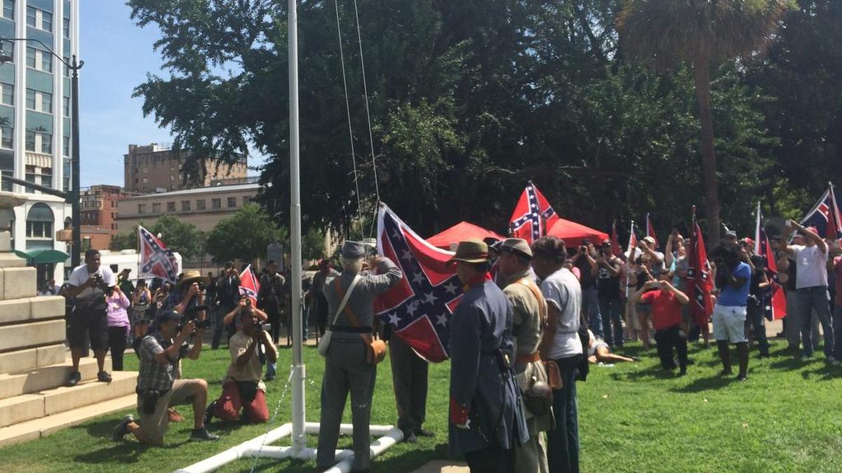 Supporters of the Confederate flag raise it on a temporary flagpole on the grounds of the Statehouse in Columbia at a rally on Sunday, July 10, 2016. Counter-protesters showed up but the event was peaceful.