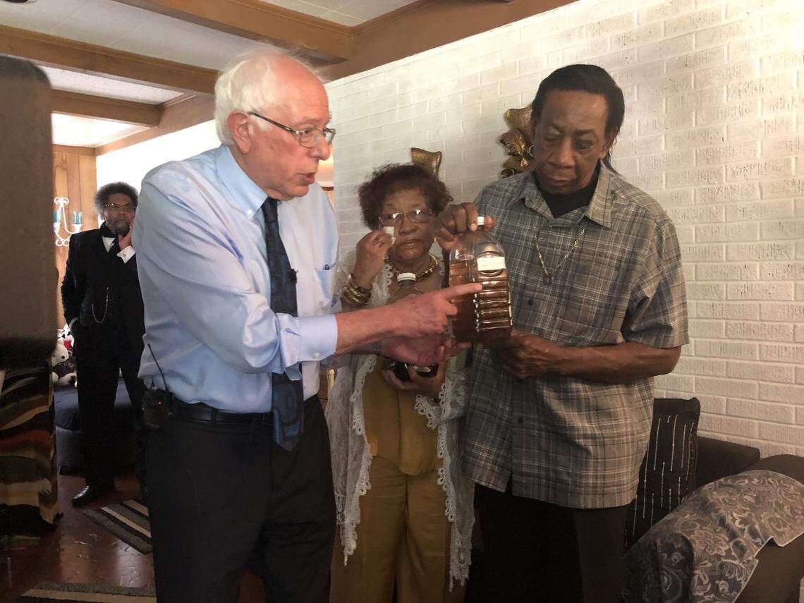 U.S. Sen. Bernie Sanders, I-Vermont, is shown discolored tap from the Denmark, SC, home of Paula Brown, center, and Eugene Smith. Sanders made the small South Carolina town’s water problems the focus of a Democratic presidential campaign town hall in Denmark on Saturday, May 18, 2019.