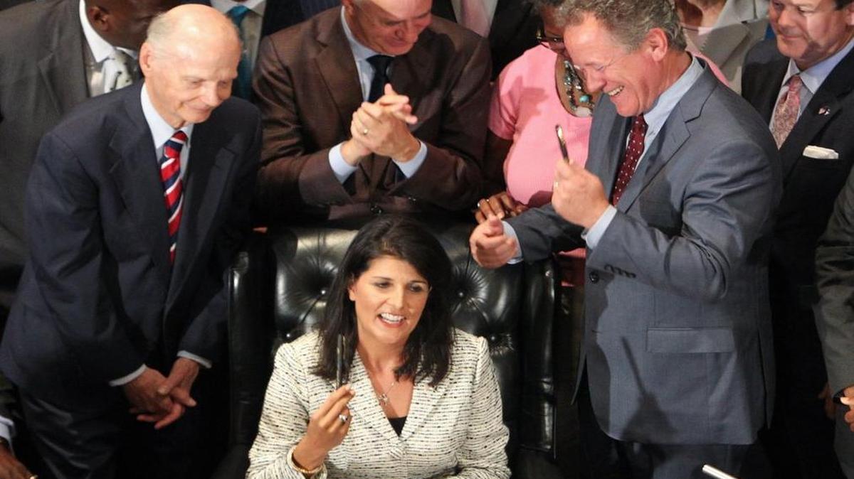 
Governor Nikki Haley presents the pens she used to sign the bill removing the Confederate flag from Statehouse grounds to Former governors, Jim Hodges and David Beasley. 
