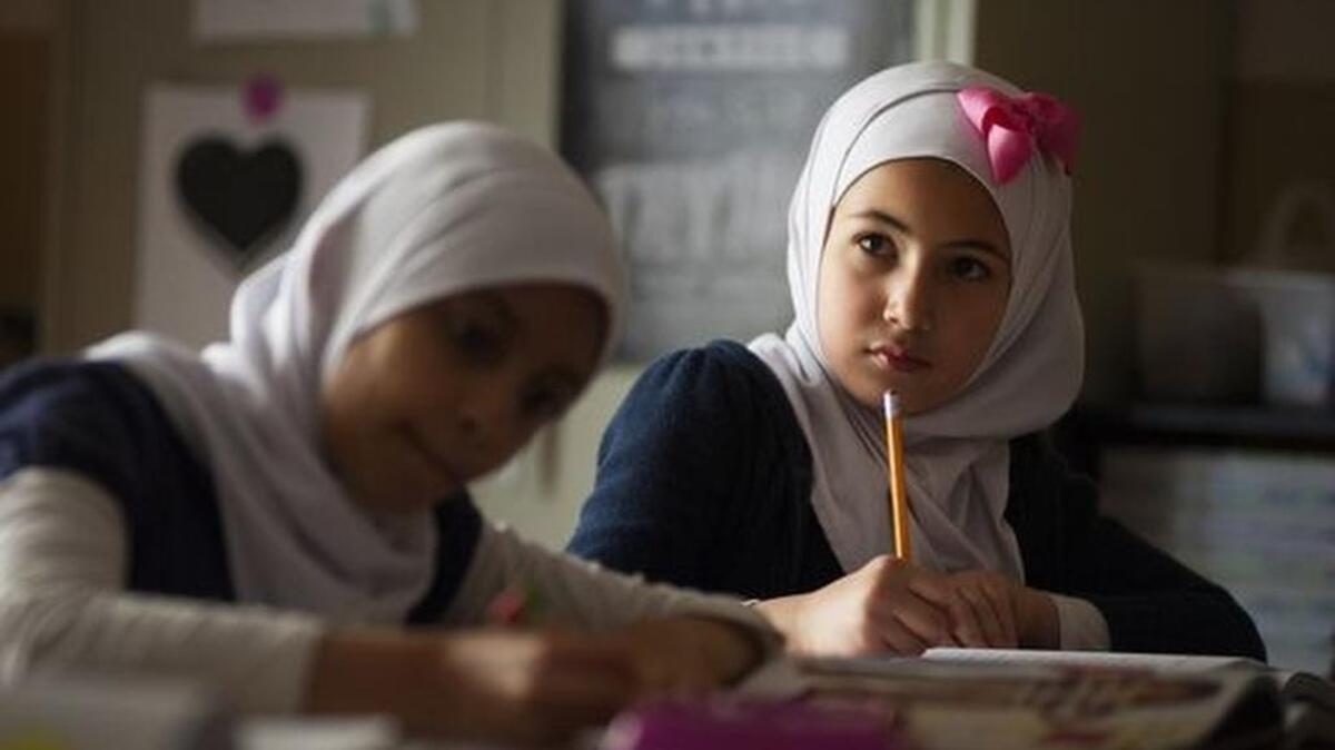 Sally Barakat, a third grader at As-Sabeel Academy, copies down vocabulary words related to sewing during English class last spring.