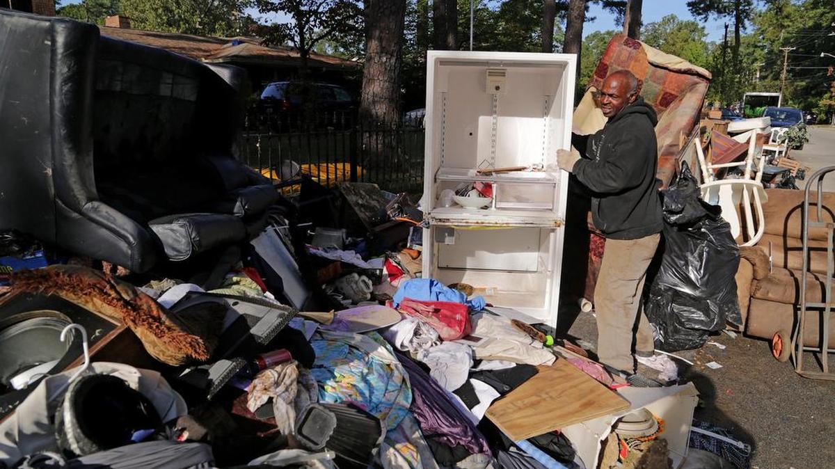 
Oswald O'Neill helps move damaged items outside of a friend's home on Kilbourne Road in Columbia on Thursday. "Even when Hugo hit it wasn't this bad," he said.
