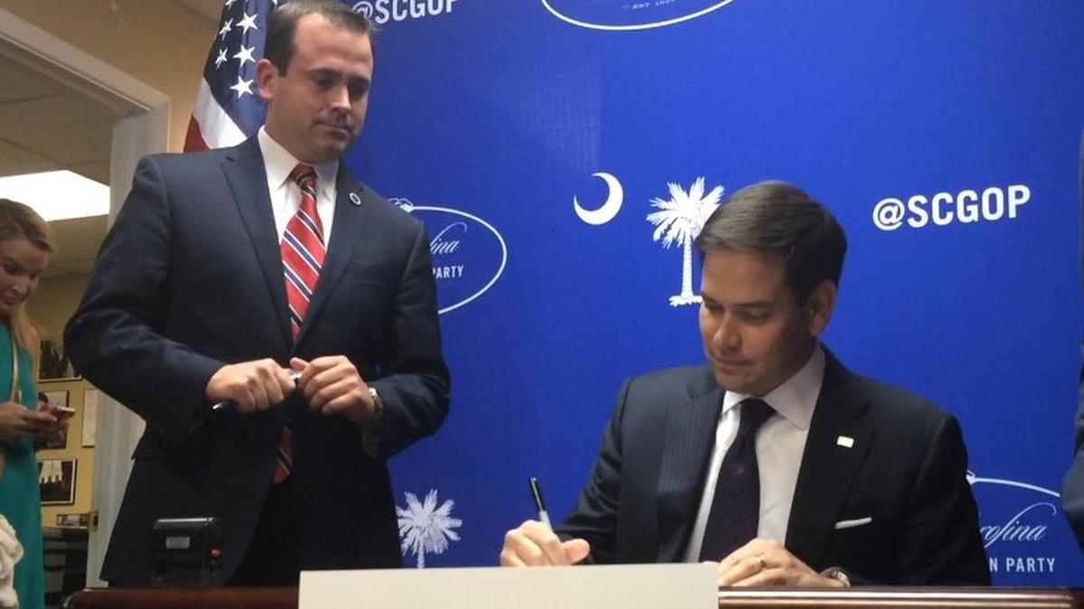 
U.S. Sen. Marco Rubio, R-Fla., signs his S.C. Republican Primary filing form. State Rep. Neal Collins, R-Pickens, (left) notarized the form. 
