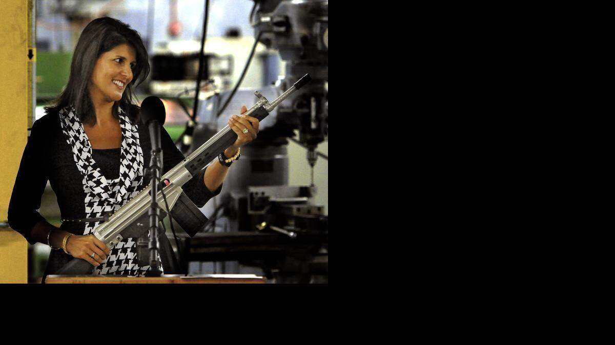 
Gov. Nikki Haley looks over a personalized PTR semi-automatic rife she was presented during a tour of the Aynor plant last year.


