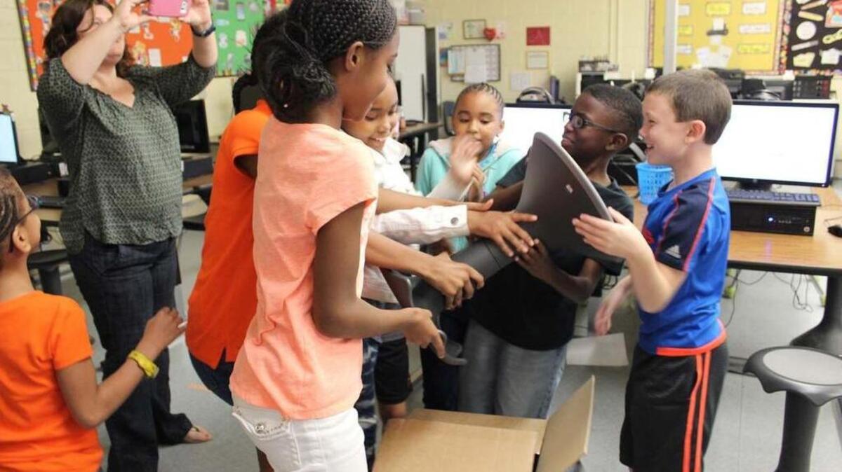 Students at Timrod Elementary School in Florence open a package containing the most recent piece of classroom furniture funded through DonorsChoose.org. Thirteen classroom stools have been added to the school’s computer lab.