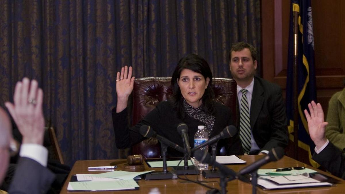 Governor Nikki Haley votes during a 2011 meeting while her then-chief of staff Tim Pearson looks on.