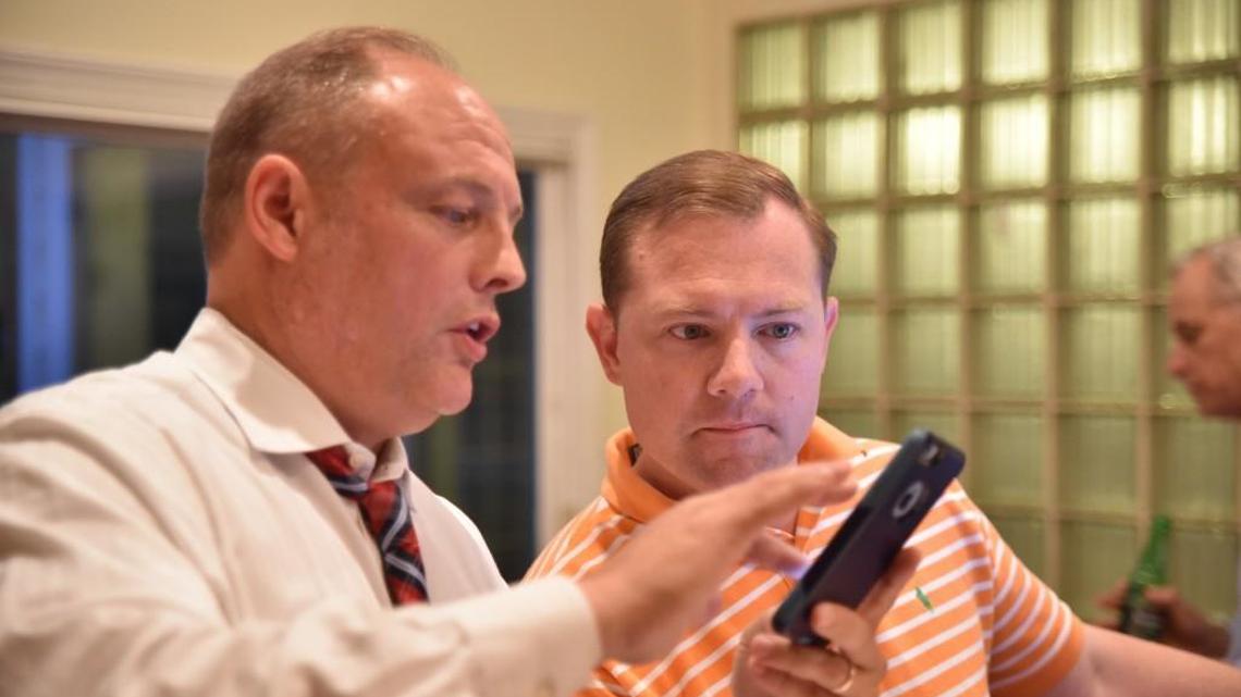 Wes Climer, center, watches Republican primary election results from the kitchen of his Rock Hill home with friends and family Tuesday night.
