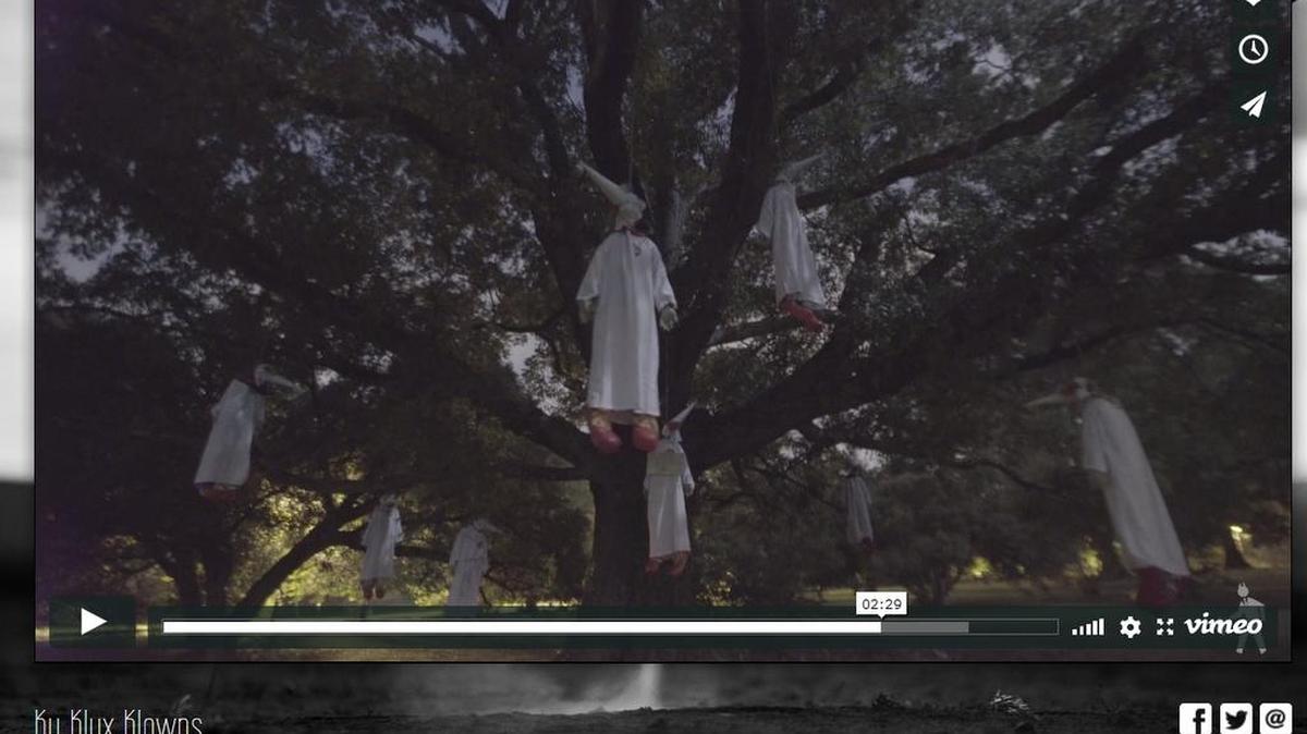 A still image from a video posted by art collective INDECLINE shows clowns in KKK robes hanging from a tree in a Richmond, Va., park