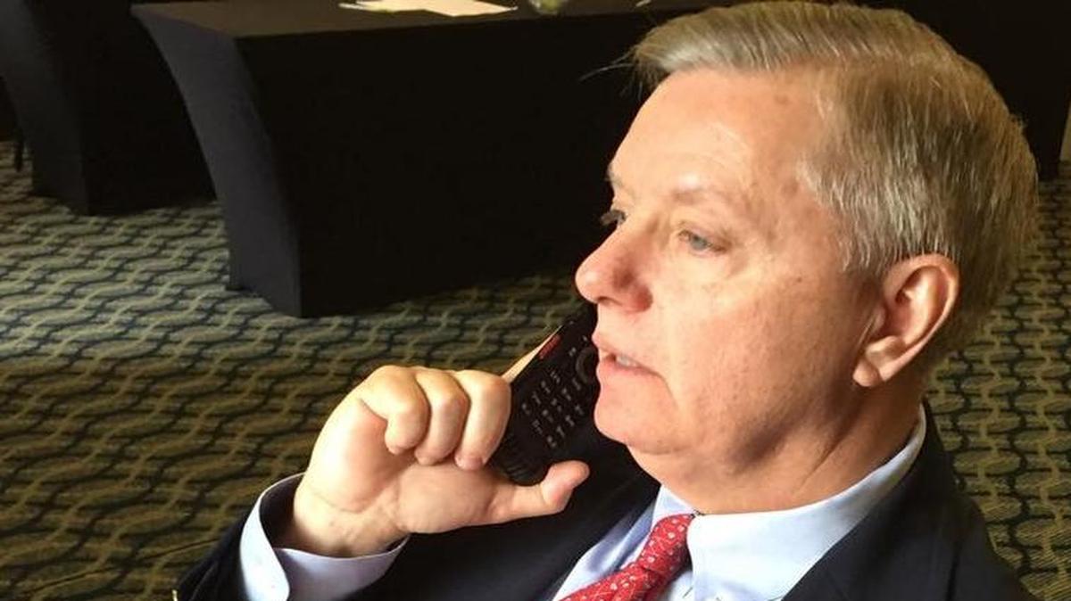 
U.S. Sen. Lindsey Graham speaks on his flip phone to Benjamin Netanyahu after the Israeli prime minister’s election victory in March. Graham said he will get a smart phone soon. 

