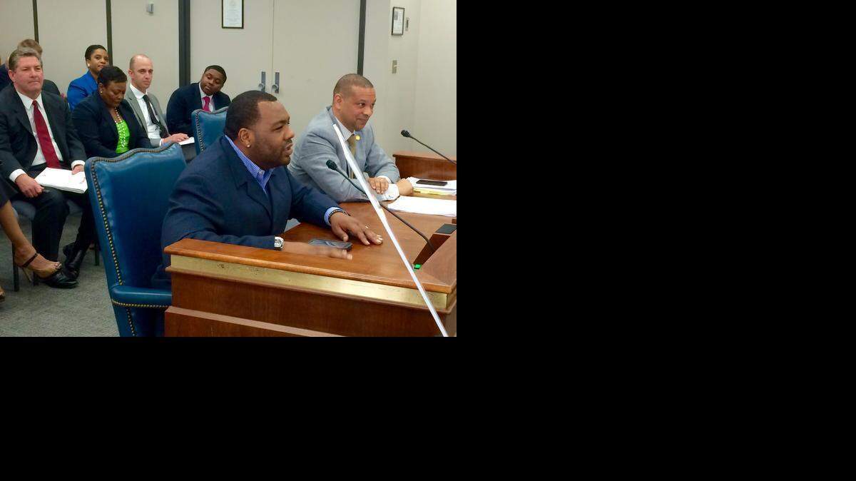 
Former University of South Carolina defensive lineman Henry Taylor testifies to a Senate panel on Wednesday. USC Athletics Director Ray Tanner (red tie) listens. 
