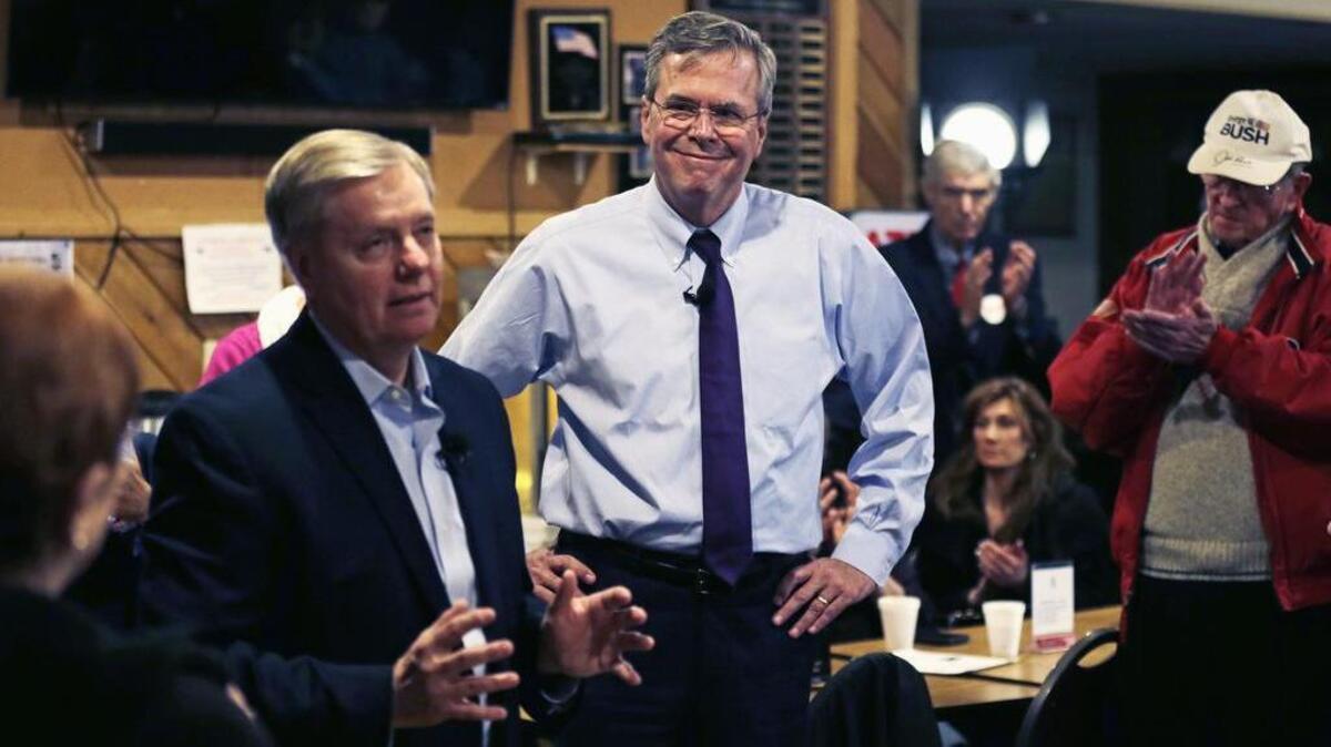 Republican presidential candidate, former Florida Gov. Jeb Bush, listens as Sen. Lindsey Graham, R-Seneca, speaks during a campaign stop at an American Legion post in Manchester, N.H., on Wednesday.