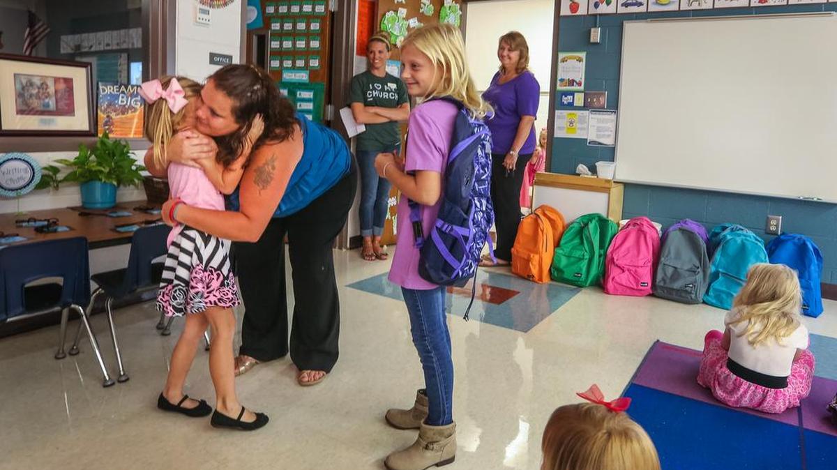 Jenny Rabon hugs her daughter, Bella, goodbye as she leaves her at her first day of kindergarten at Saxe Gotha Elementary in Lexington in August.