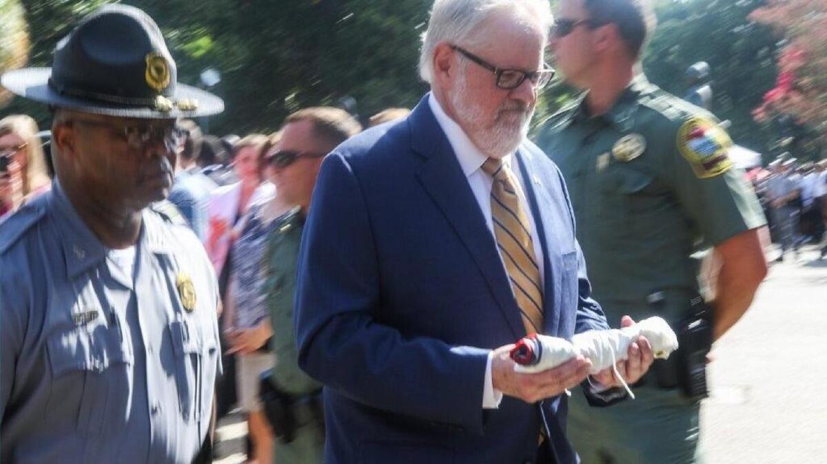 
Allen Roberson, director at SC Confederate Relic Room & Military Museum, carried the Confederate flag that was removed from the State House grounds during the July 10 ceremony to a waiting car for transport to the museum. 

