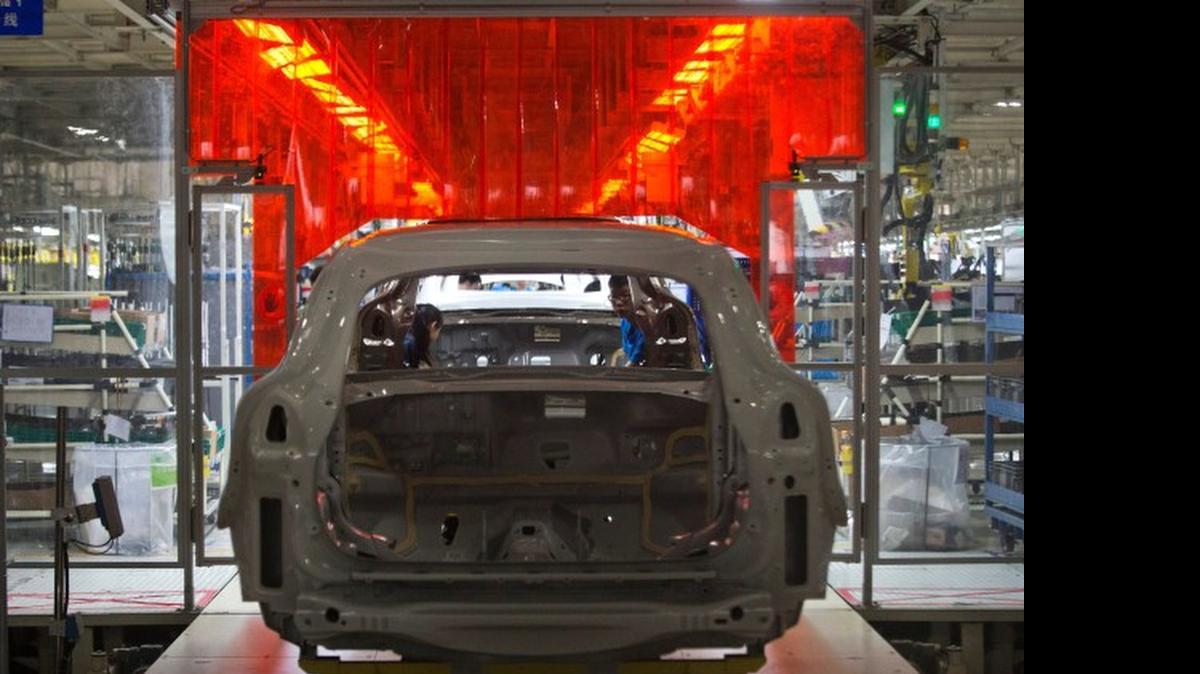 
A worker examines the metal frame of a car at an assembly line of a Volvo factory in Chengdu in southwestern China's Sichuan province. 

