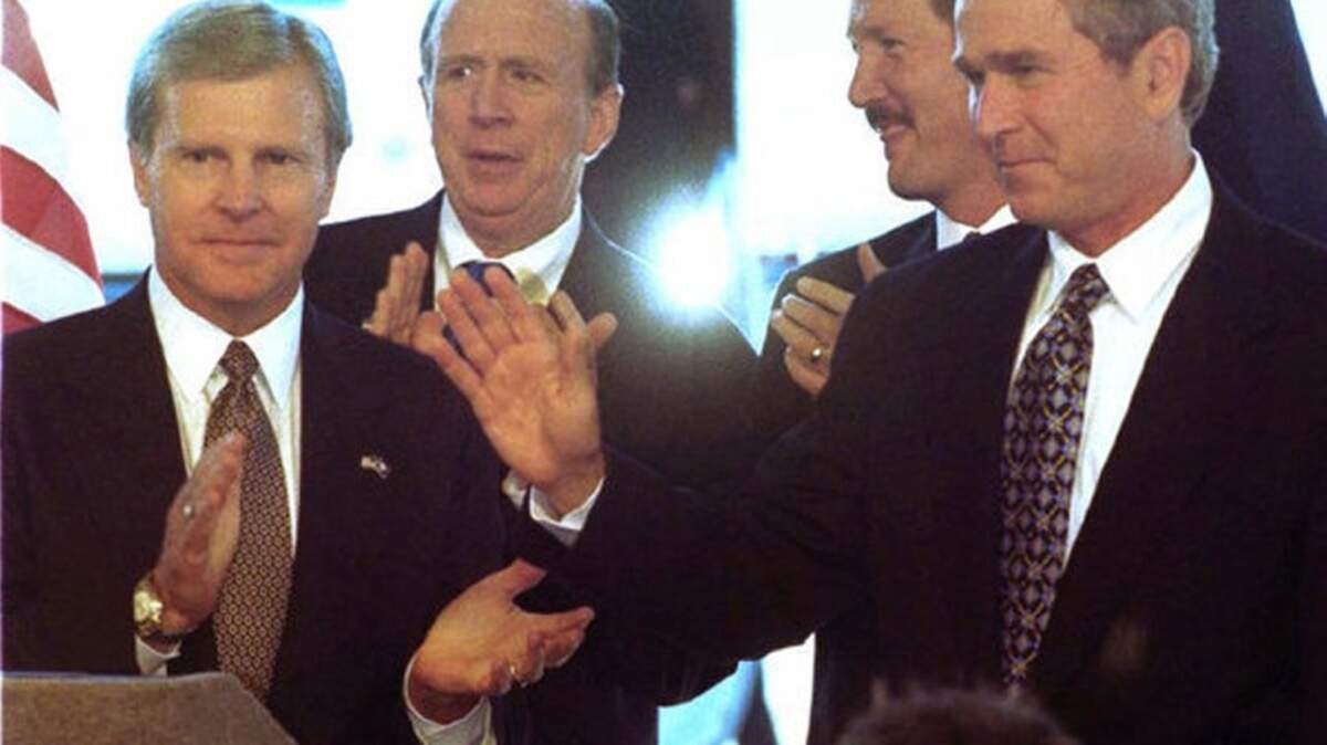 Then Texas governor and presidential hopeful George W. Bush, right, greets supporters after he arrives in Columbia in this Sept. 23, 1999 file photo taken during a campaign stop, as former South Carolina Gov. Carroll Campbell , left, claps. Also on the stage in this photo are South Carolina House Speaker David Wilkins, second from left, and Lt. Governor Bob Peeler, right-center.