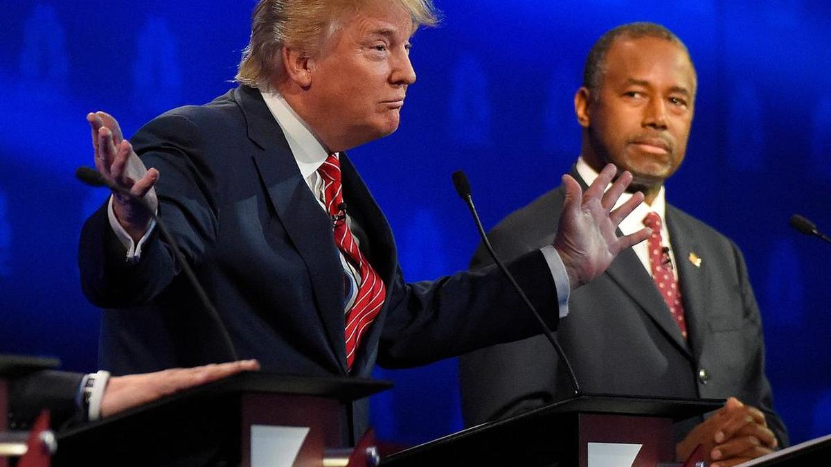 Ben Carson, right, watches as Donald Trump speaks during the CNBC Republican presidential debate at the University of Colorado on Wednesday.