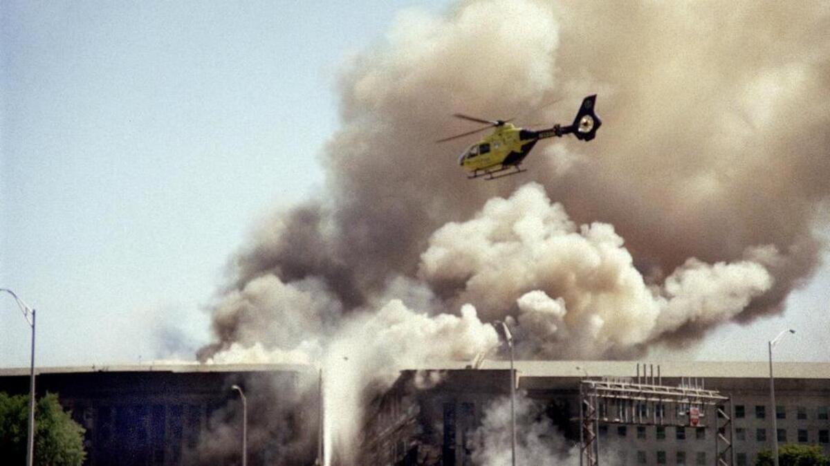 
FILE - In this Sept. 11, 2001 file photo, a helicopter flies over the Pentagon in Washington as smoke billows over the building. Partial remains of several 9/11 victims were incinerated by a military contractor and sent to a landfill, a government report said Tuesday, Feb. 28, 2012, in the latest of a series of revelations about the Pentagon's main mortuary for the war dead. The terrorist-hijacked airliner that slammed into the west side of the Pentagon killed 184 people. 
