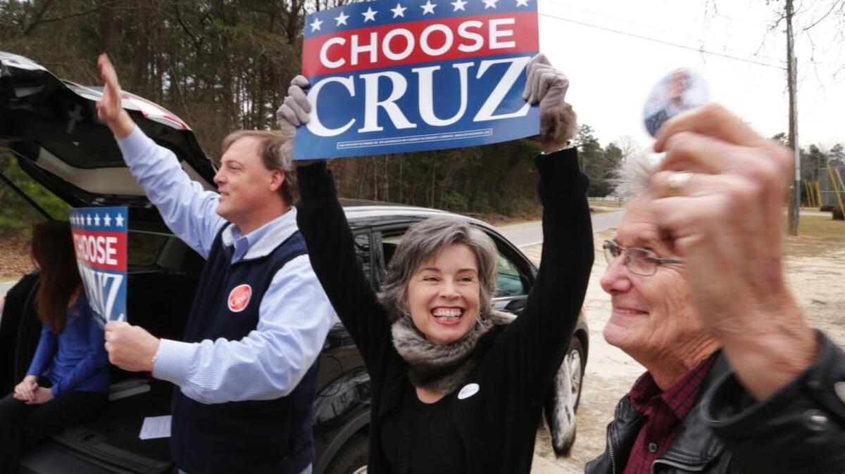 Brad Wasson, left, and Mary and Leonard Bliss, of Lexington, hold signs in support of Ted Cruz on Saturday.
