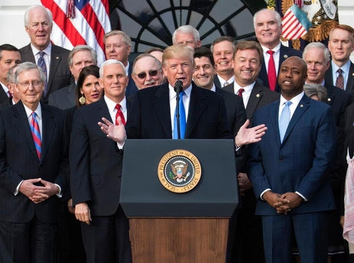 President Donald Trump joined by Senate Majority Leader Mitch McConnell of Ky., Vice President Mike Pence, Speaker of the House Paul Ryan, R-Wis., Sen. Tim Scott, R-S.C., front right, and other members of congress, speaks during an event on the South Lawn of the White House in Washington, Wednesday, Dec. 20, 2017, to acknowledge the final passage of tax overhaul legislation by Congress.