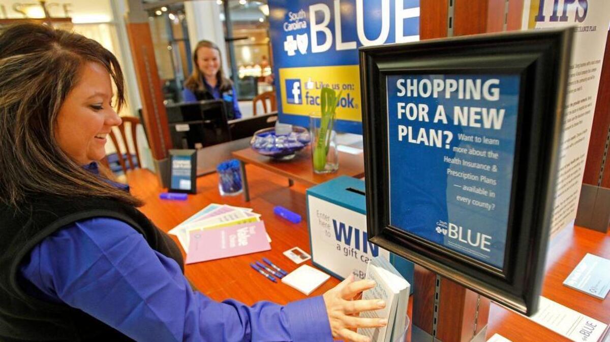 FILE PHOTO: Amanda Butler, manager of Blue Cross Blue Shield's South Carolina Blue retail center, arranges some items at their kiosk inside Columbiana Centre mall.