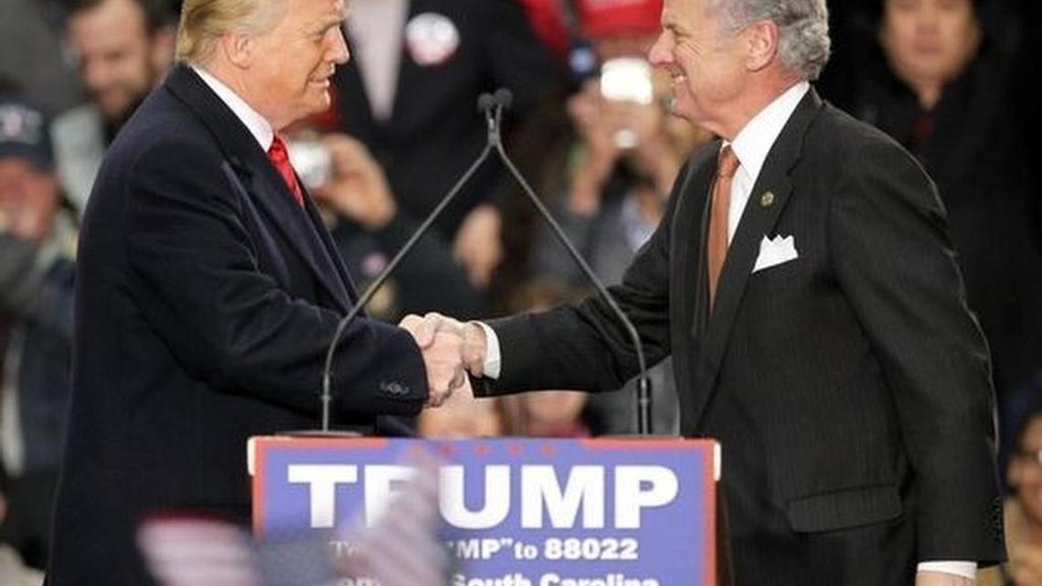 Then-Republican presidential candidate Donald Trump speaks with South Carolina Lt. Gov. Henry McMaster after McMaster introduced him to a large crowd at the T. Ed Garrison Livestock Arena.