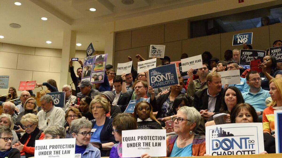 Members of the audience hold up signs before the start of Monday's City Council meeting's vote on the nondiscrimination ordinance, Feb. 22, 2016.