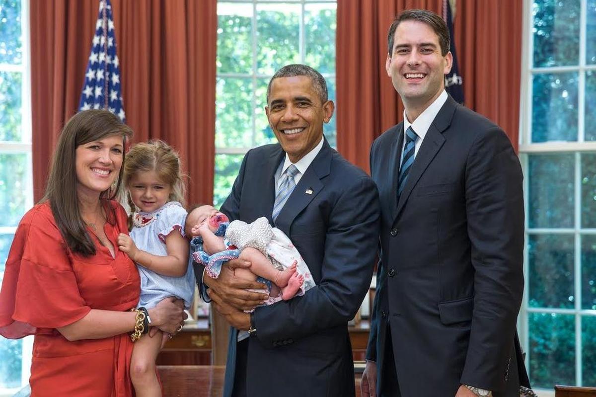 In this July 25, 2014 photo, President Barack Obama has departure photos taken with Fran Person, personal aide to Vice President Joe Biden, and family in the Oval Office.