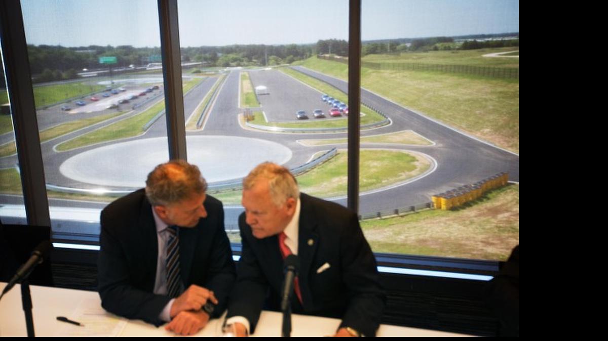 
A driver development track is seen in the background as Georgia Gov. Nathan Deal, right, talks with Detlev von Platen, president and CEO of Porsche Cars North America, left, before a press conference for the opening of the company’s new North American headquarters, dubbed the Porsche Experience Center, Thursday, May 7, in Atlanta. 

