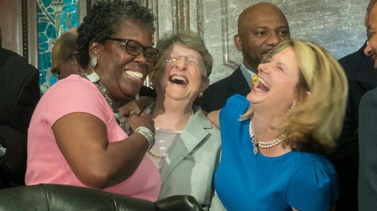 FILE PHOTO (July 2015) Rep. Gilda Cobb-Hunter, SC Chief Justice Jean Toal and Rep. Jenny Horne have a laugh before South Carolina Gov. Nikki Haley signs the bill that will remove the Confederate Battle Flag from the State House grounds.