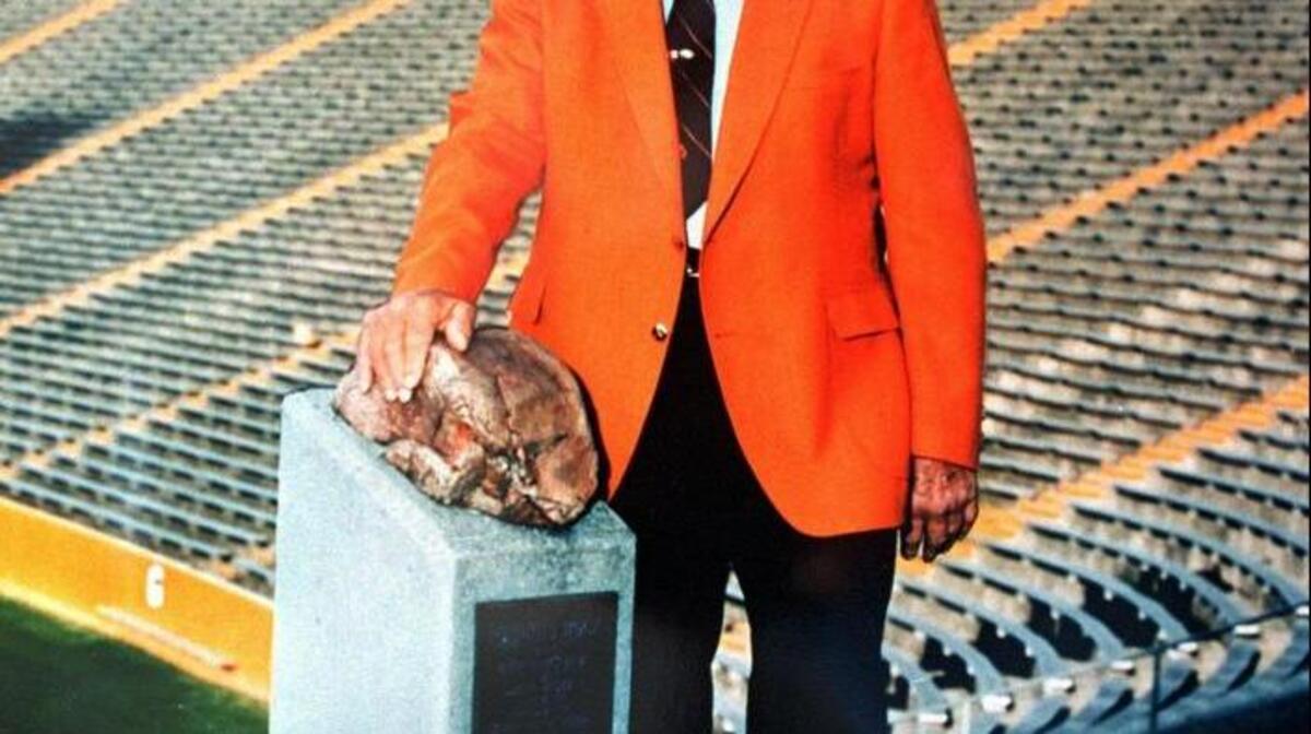 Former Clemson football coach Frank Howard poses in this l990 file photo with his hand on ‘Howard's Rock.’ The Rock was given to Howard by a friend who pick it up in Death Valley, Calif. Supposedly having mystical qualities, Clemson player rub the rock before running on the field at home games. Howard died in 1996.