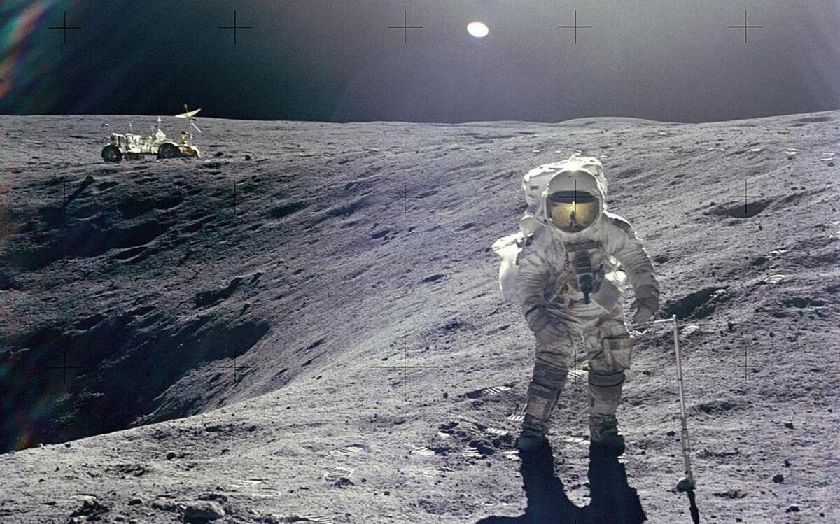 Astronaut Charles M. Duke Jr., Lunar Module pilot of the Apollo 16 mission, is photographed collecting lunar samples at Station no. 1 during the first Apollo 16 extravehicular activity at the Descartes landing site. This picture, looking eastward, was taken by Astronaut John W. Young, commander. Duke is standing at the rim of Plum crater, which is 40 meters in diameter and 10 meters deep. The parked Lunar Roving Vehicle can be seen in the left background.