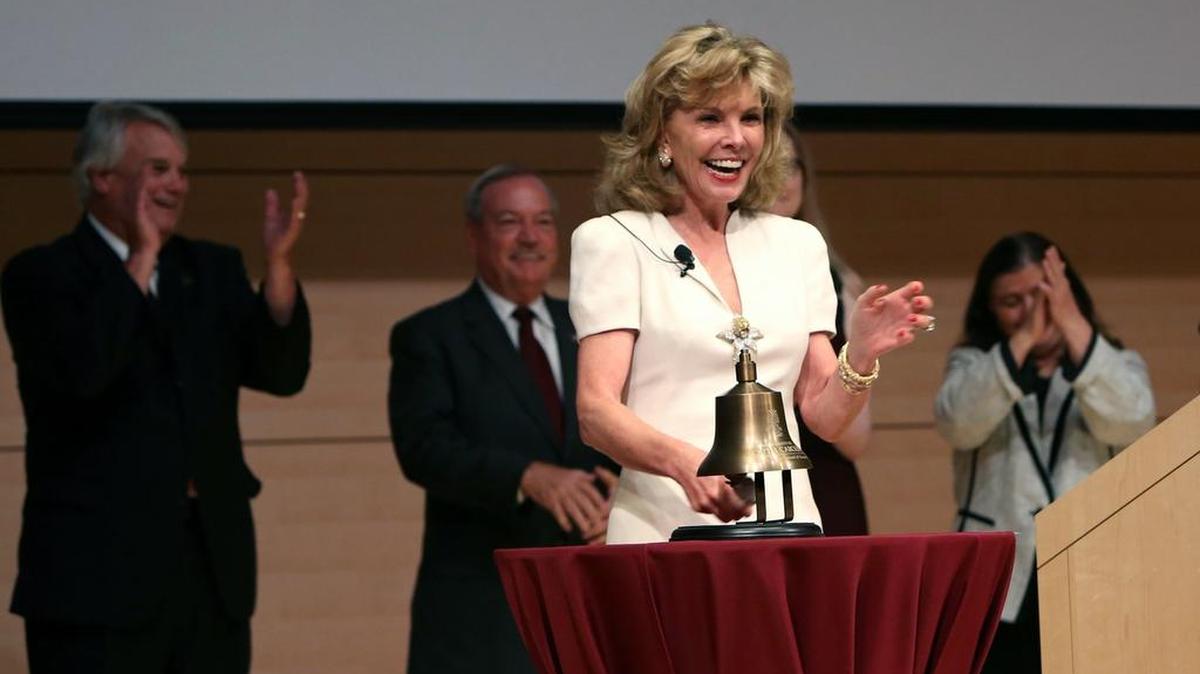 Darla Moore applauds ringing the opening bell during the grand opening celebration of the $106.5 million business school building that bears her name.