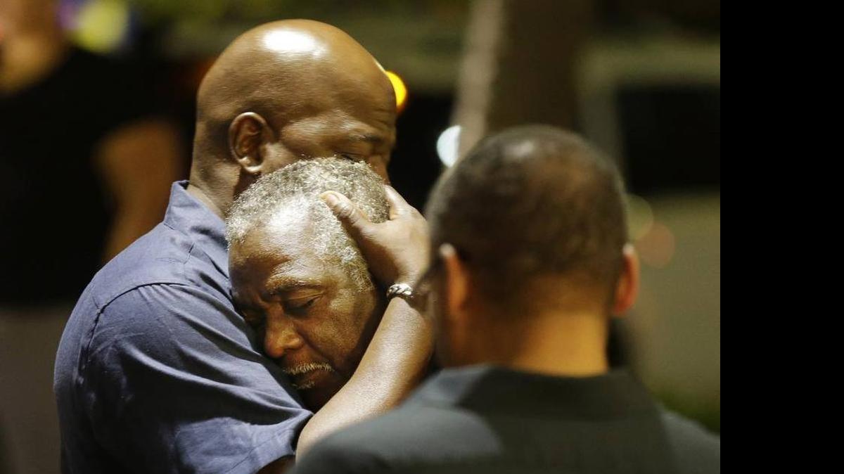 
Worshippers embrace following a group prayer Wednesday night across the street from the scene of a shooting at Emanuel AME Church in Charleston. 
