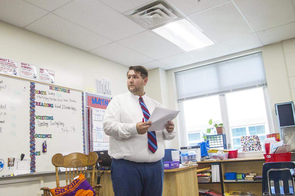 Thomas McAuliff, a fourth grade teacher at Taylors Elementary, leads his students through a worksheet before they go out to recess. McAuliff works part time at Sears to help support his teacher's salary.