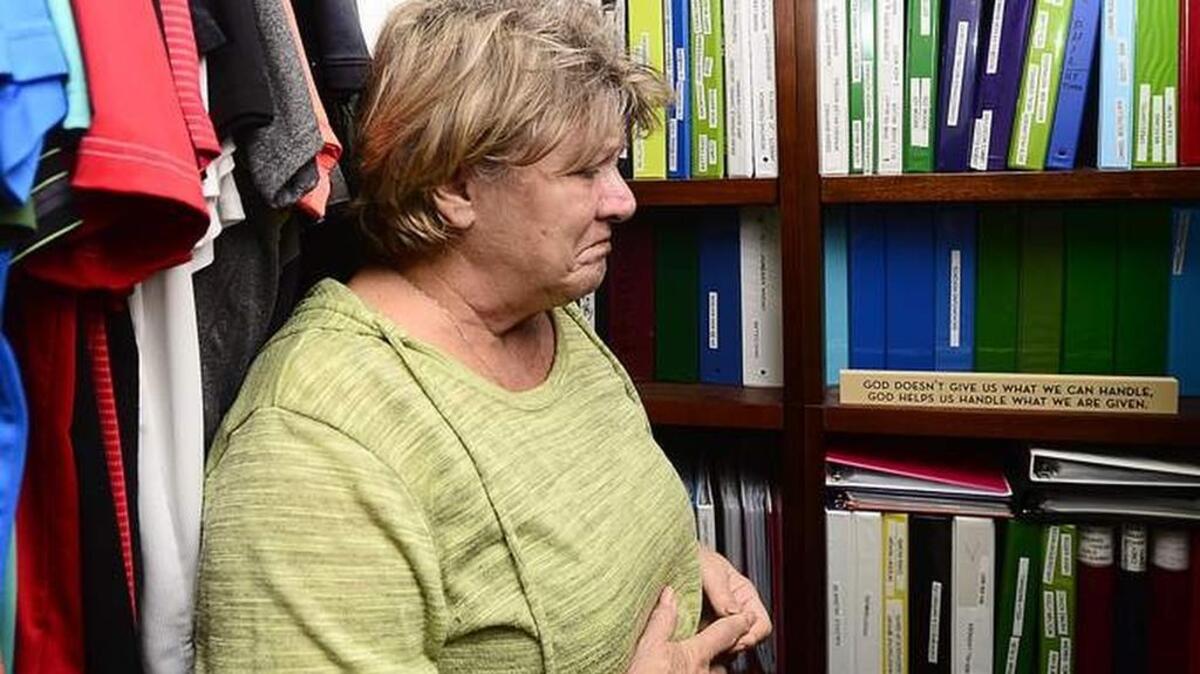 Lorraine Lucas, mother of homicide victim Brian Lucas, stands in front of stacks of files the family has kept over the years to investigate the death of their son at Superbike Motorsports in 2003. The case remains unsolved.