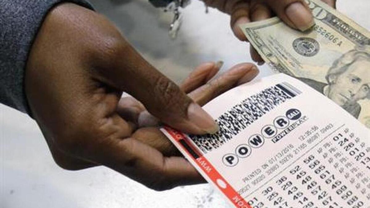In this Jan. 13, 2016, file photo, a clerk hands over a Powerball ticket for cash at Tower City Lottery Stop in Cleveland. Powerball estimates that its jackpot for the May 7, 2016, drawing is $415 million.