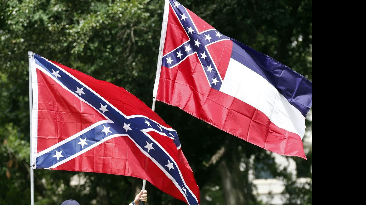
In this July 6, 2015 photograph, a small group of Mississippi and Confederate flag-waving citizens participate in a rally on the steps of the Capitol in Jackson, Miss., sponsored by the Magnolia State Heritage Campaign, seeking publicity and support to help keep the Confederate battle emblem in the Mississippi flag. Mississippi is the only state that includes the Confederate battle emblem in its state flag. The rebel X has been there since 1894. 
